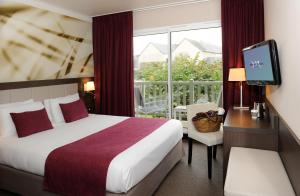 ein Hotelzimmer mit einem Bett, einem TV und einem Balkon in der Unterkunft Mercure Bayeux Omaha Beach in Port-en-Bessin-Huppain