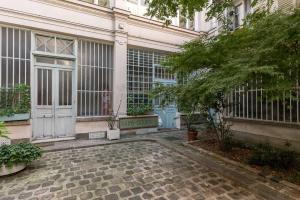 una entrada a un edificio con una puerta blanca en République - Charmant studio - Haystia, en París