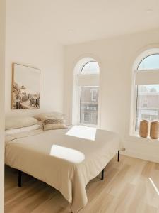 a white bedroom with a bed and two windows at On Trend - 427 Haven in Woodstock