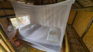 a bed in a room with a mosquito net at Tarzan Bamboo hut in Khao Sok National Park +24 photos