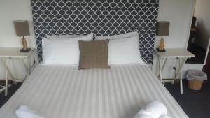 a bedroom with a large white bed with two tables at Fish Creek Hotel in Fish Creek