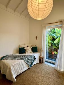 ein Schlafzimmer mit einem Bett und einem großen Fenster in der Unterkunft Time to Travel to Terceira in Pesqueiro