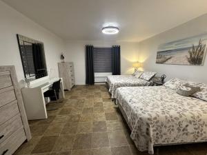 a bedroom with two beds and a desk and a sink at Pointe Calumet, 30 minutes de Montréal in Pointe-Calumet