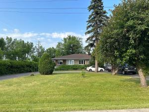 a house with a car parked in a yard at Pointe Calumet, 30 minutes de Montréal in Pointe-Calumet