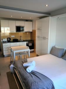 a bedroom with a bed and a table and a kitchen at Bay View Albufeira in Albufeira