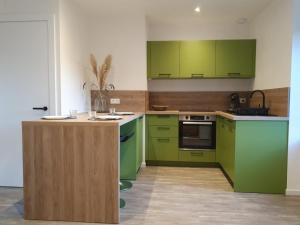 una cucina con mobili verdi e un piano di lavoro di De l'herbe jusqu'aux genoux - appartement 60 m2 a La Vancelle
