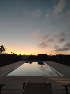 einen Sonnenuntergang über einem Pool mit Sonnenuntergang in der Unterkunft Villa Estrella de Blanca in La Oliva