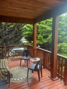 a wooden deck with chairs and a table on it at Emerald Hill Cabin in Mount Pleasant