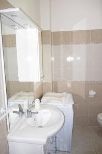 ソラナスにあるLe Palmeの洗面台、鏡、トイレ付きのバスルーム