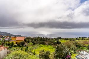 uma vista para um campo verde e um céu nublado em GuestReady - Restful Getaway in Madeira em Estreito da Calheta
