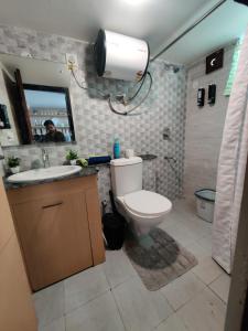 a bathroom with a toilet and a sink and a mirror at Zen Haven - Luxury Ganga Access & Mountain View in Rishīkesh