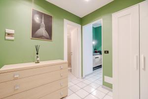 a kitchen with green walls and a dresser in a room at Stylish Studio in Turin's Vibrant Quadrilatero in Turin +2 photos