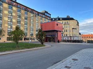 an empty street in front of a large brick building at Charming City Studio, 10 Min Walk to Train Station in Stockholm