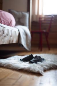 a white rug on the floor in front of a bed at BuchackerAlm -1,5h panoramic walk in Angerberg