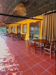 a restaurant with tables and chairs and a yellow wall at LUX HOME Phước Hải in Hội Mỹ +61 photos