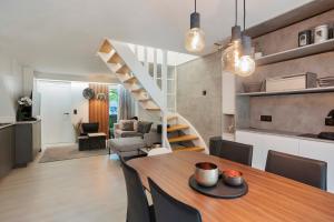 胡塔伦Bos-Chalet bij Wijers Wandelroutes, Rust & Gezinsplezier Fijnspar 108 Hengelhoef的厨房以及带桌子和楼梯的客厅。