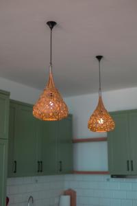 three lights hanging from the ceiling in a kitchen at Escape by Form Apartament 3 in Dhërmi