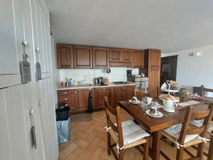 a kitchen with a wooden table with chairs and a refrigerator at Civico 5 in Assisi +27 photos