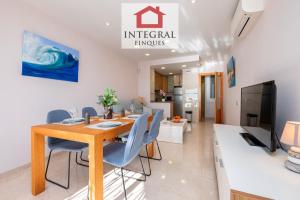 a dining room with a wooden table and blue chairs at Blue Wave Apartment in Calonge