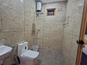 un baño con inodoro y lavabo en Zira Homestay, en Munnar