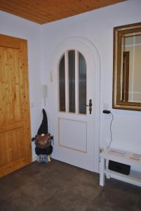 a room with a white door with a cat sitting in a chair at Ferienwohnung Eschental in Eschenlohe