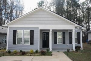 a white house with a black door at Raleigh With Daylor in Raleigh