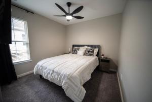 a bedroom with a bed and a ceiling fan at Raleigh With Daylor in Raleigh
