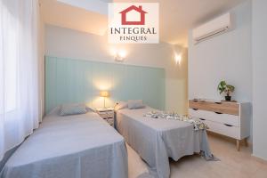 two beds in a room with a sign that reads imperial hugs at Blue Wave Apartment in Calonge