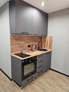 a kitchen with a stove and a sink at Квартира in Pavlodar