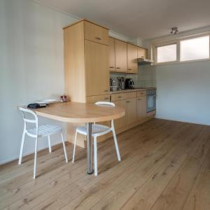 a kitchen with a wooden table and two chairs at Appartementen Domburg in Domburg