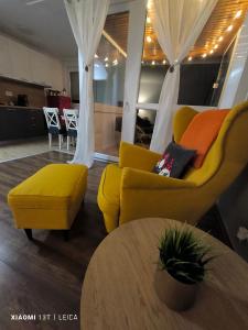 ein Wohnzimmer mit einem gelben Sofa und einem Tisch in der Unterkunft Apartman Lamarti in Samobor