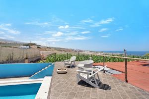 un patio con 2 sedie e una piscina di Finca la Calabacera Casa Amarilla a Playa de San Juan