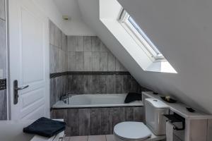 a bathroom with a toilet and a bath tub at Villa DUXCAAR in Saint-Pabu