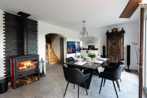 a dining room with a fireplace and a table and chairs at Villa DUXCAAR in Saint-Pabu