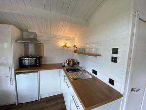 a small kitchen with white cabinets and a sink at Lochside-1Bed-Pet Friendly-Amazing views in Alexandria