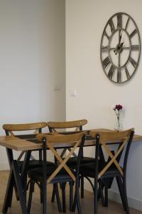 a dining room table and chairs with a clock on the wall at Best Apartments-Aqua-Belgrade Waterfront in Belgrade +37 photos