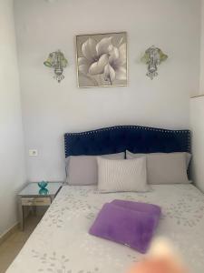 een bed met een paars kussen erop bij El Palmeral in Playa Blanca +13 foto's