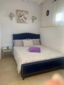 een bed met een paars kussen erop bij El Palmeral in Playa Blanca