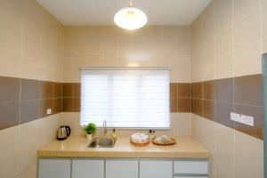 a kitchen with a sink and a window at Arista Guest House in Pasir Bogak