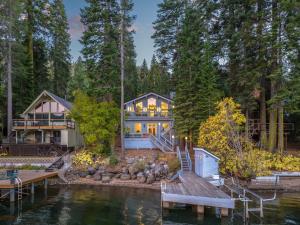 a large house on the water with a dock at Luxury Lakefront 5 Br Home Hot Tub Arcade in Truckee
