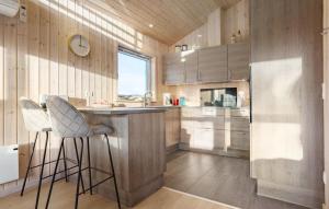 a kitchen with wooden walls and a counter and stools at Awesome Home In Vestervig With Sauna in Vestervig