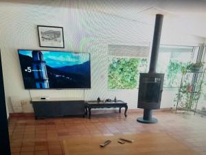 a living room with a flat screen tv and a table at La grangette in Marseillan