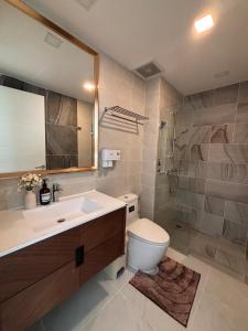 a bathroom with a toilet and a sink and a mirror at 2BR 4Beds Luxury Condo Pool & Fitness in Phuket Town