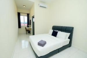 a bed with a black headboard in a room at Arista Guest House in Pangkor