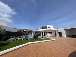 una casa con un patio con mesas y sillas en Villa Maria, en Playa Blanca