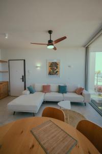 a living room with a couch and a ceiling fan at Escape by Form Apartament 4 in Dhërmi