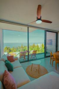 a living room with a couch and a ceiling fan at Escape by Form Apartament 4 in Dhërmi