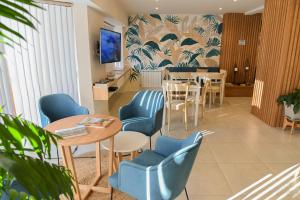 a waiting room with tables and chairs and a wall at La Morada Petit Hotel in Neuquén