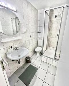 a white bathroom with a sink and a toilet at Hotel Breuer in Hamm +22 photos