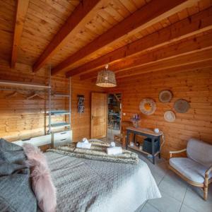a room with a bed and a fireplace in a cabin at Chalet Lipa - Confort et Sauna au cœur des Vosges in La Bresse